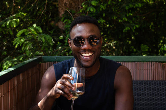 Young adult holding a natural wine bottle with moody lighting, representing Gen Z wine drinking trends in 2024