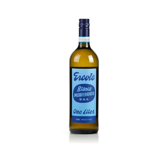Bottle of Ercole Bianco Monferrato 2023 (1L) with lemons, fresh herbs, and chilled glassware on a marble counter.