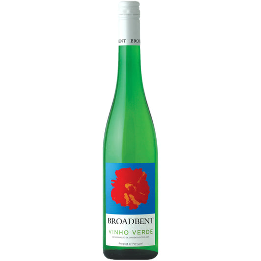 Broadbent Vinho Verde bottle chilled on a patio table with lime wedges, oysters, and a sea breeze in the background.