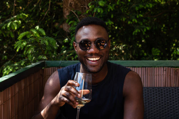Young adult holding a natural wine bottle with moody lighting, representing Gen Z wine drinking trends in 2024