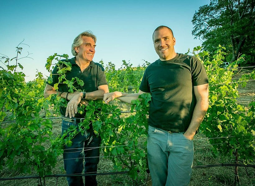 Two winemakers standing among grapevines at Kongsgaard in Napa Valley