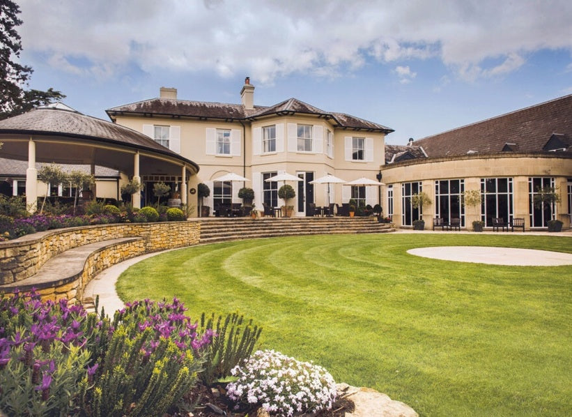 Landscaped winery estate building, green lawn and garden flowers, featured for Peter Michael Winery